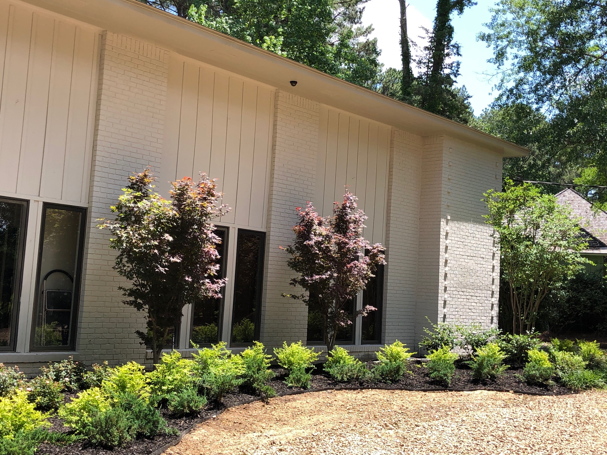 Superscapes landscaping — planted beds and stone-edged lawn